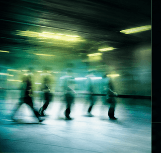 People moving through a luminous station, captured in motion